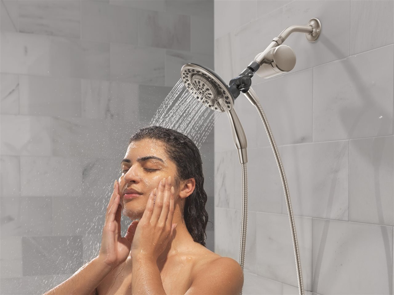 Woman showing under a rainfall faucet
